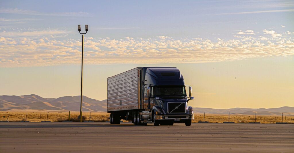 Caminhão grande transporta container em área seca - Vectorlog
